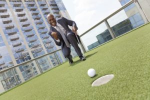Businessman playing golf on a rooftop course
